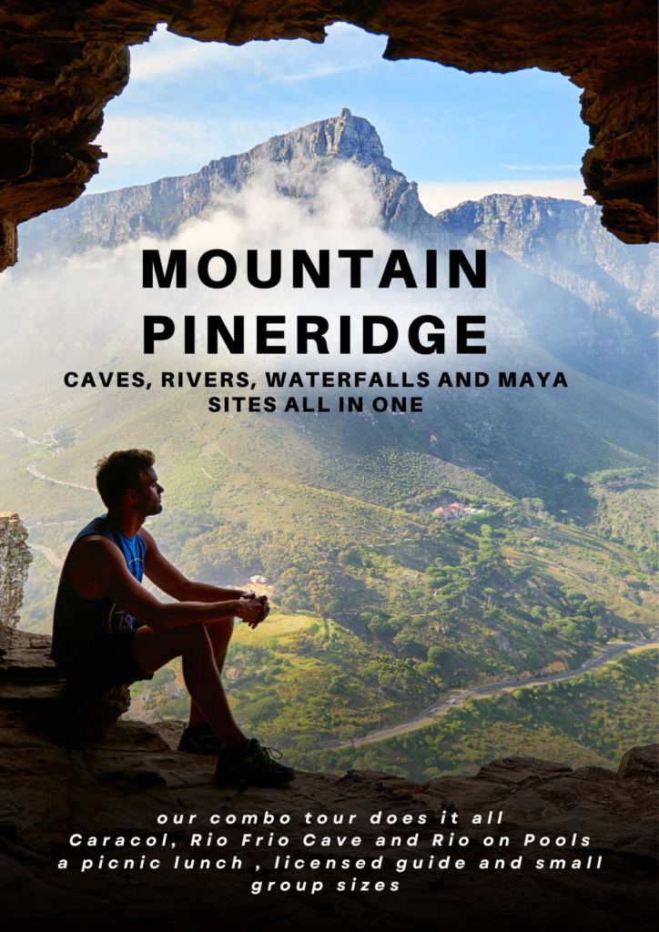 person sitting on the edge of cave with mountain view